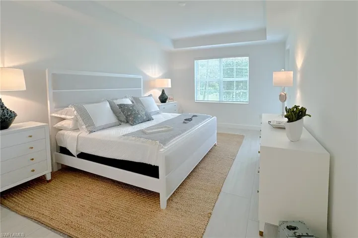 Bedroom featuring a raised ceiling and baseboards