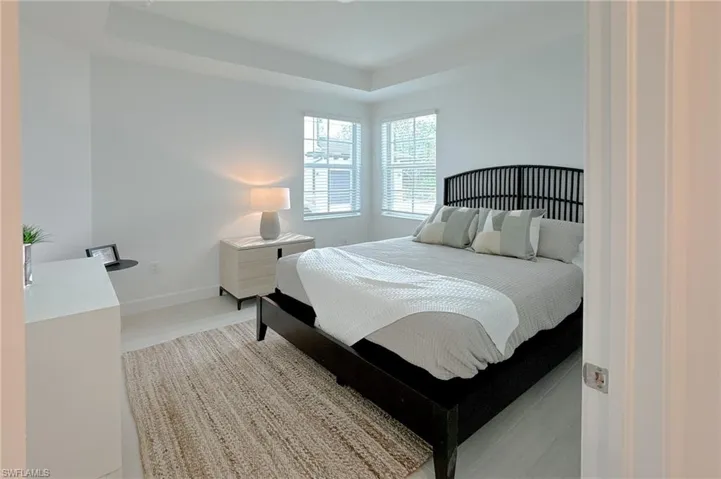 Bedroom with a raised ceiling and wood finished floors