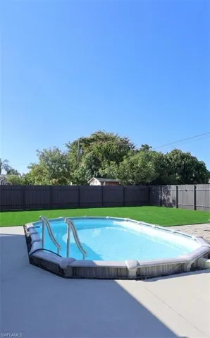 View of pool featuring a fenced backyard and patio surround