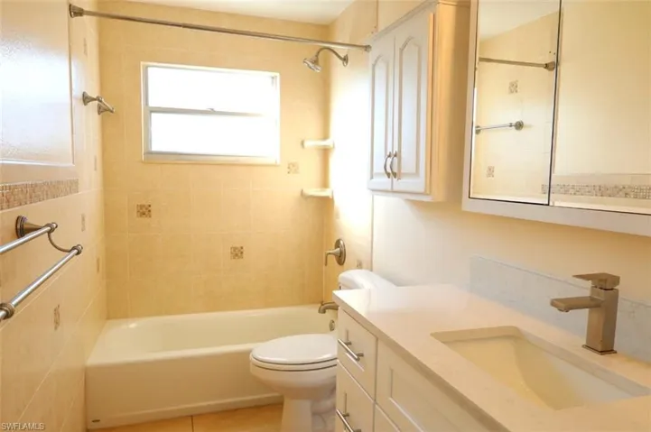 Full bath with vanity, tub / shower combination, and light tile patterned flooring