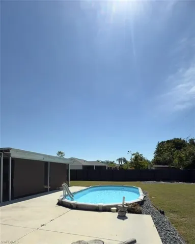 View of swimming pool with a fenced backyard and a patio