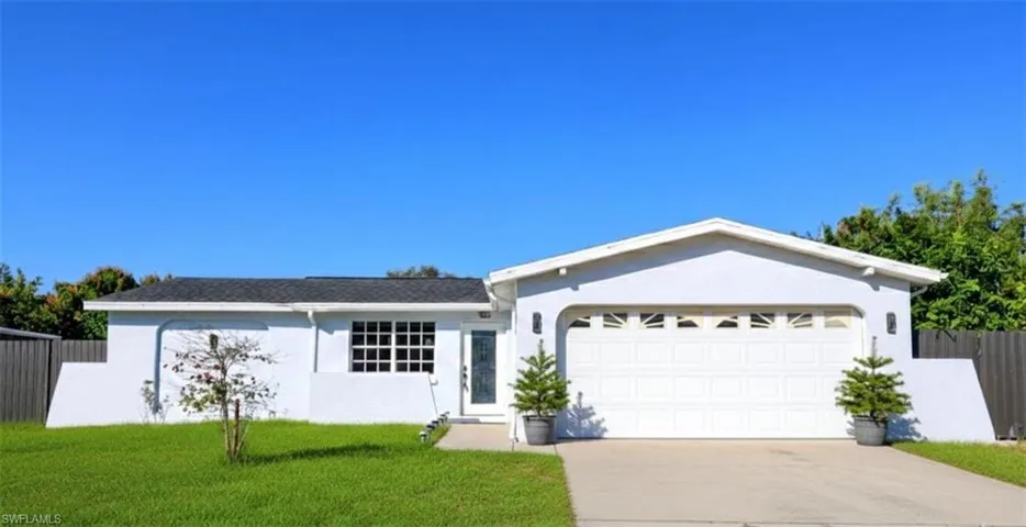 Ranch-style home with an attached garage, driveway, and stucco siding