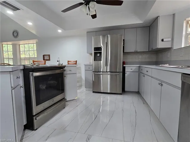 Kitchen with a ceiling fan, visible vents, recessed lighting, marble finish floor, and stainless steel appliances