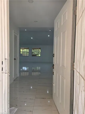 Hallway featuring recessed lighting and marble finish floor