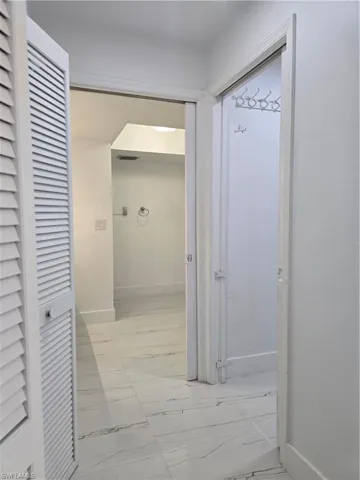 Hallway featuring visible vents, marble finish floor, and baseboards
