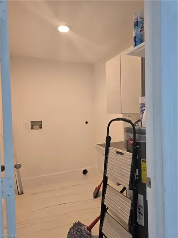 Laundry room with baseboards, washer hookup, laundry area, hookup for an electric dryer, and water heater