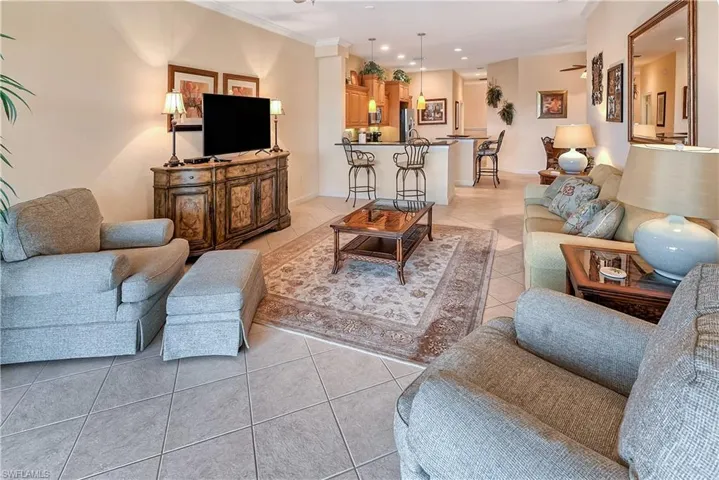 Living area with light tile patterned floors, ceiling fan, crown molding, and recessed lighting