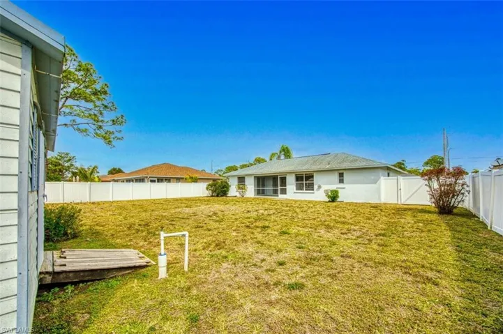 View of yard with a fenced backyard and a gate