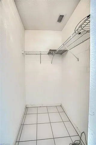 Walk in closet featuring visible vents and light tile patterned floors