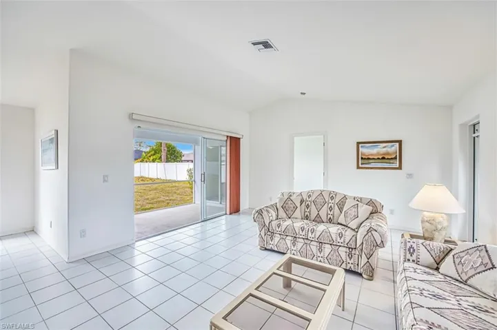 Living room featuring sliding glass doors that exit to screened in lanai