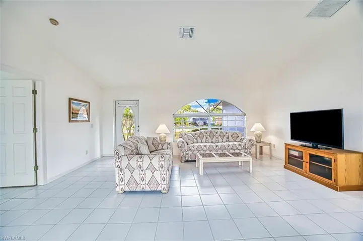 Tiled living room with a healthy amount of sunlight and vaulted ceiling