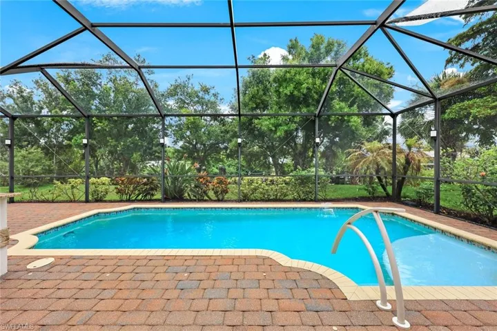 View of pool featuring a large pavered patio and a screened lanai