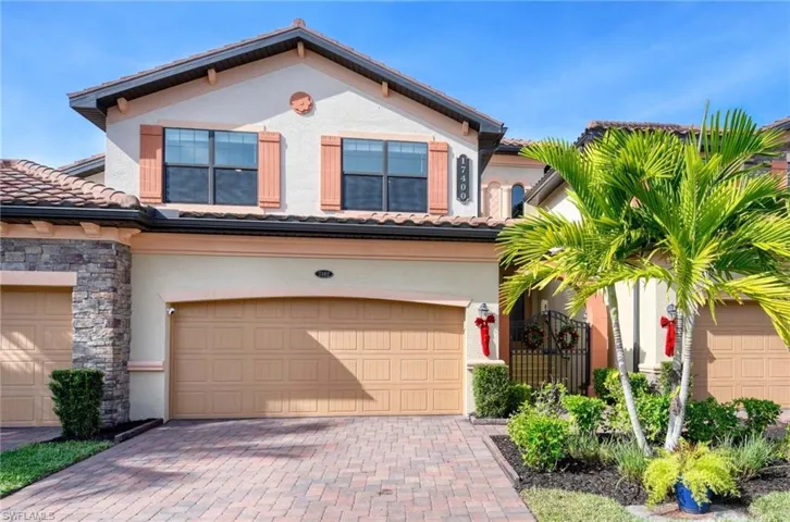 Mediterranean / spanish house with stucco siding, a tile roof, and decorative driveway