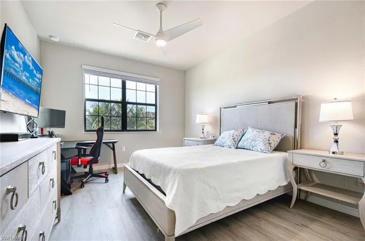 Bedroom featuring a desk, light wood finished floors, and ceiling fan