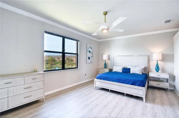 Bedroom with ornamental molding, light wood finished floors, and ceiling fan