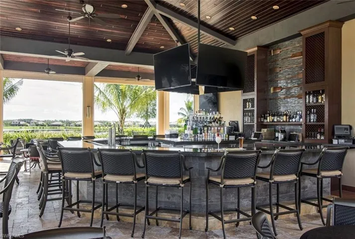 Bar featuring wood ceiling, ceiling fan, and a towering ceiling