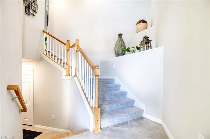 Stairway featuring a towering ceiling and tile patterned floors