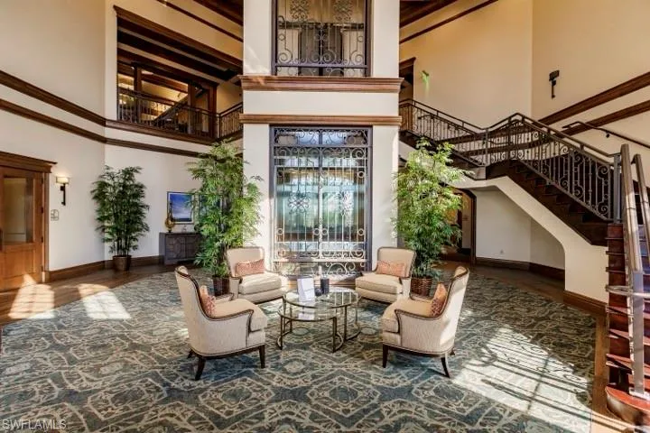 Common area with stairway, a towering ceiling, and ornamental molding