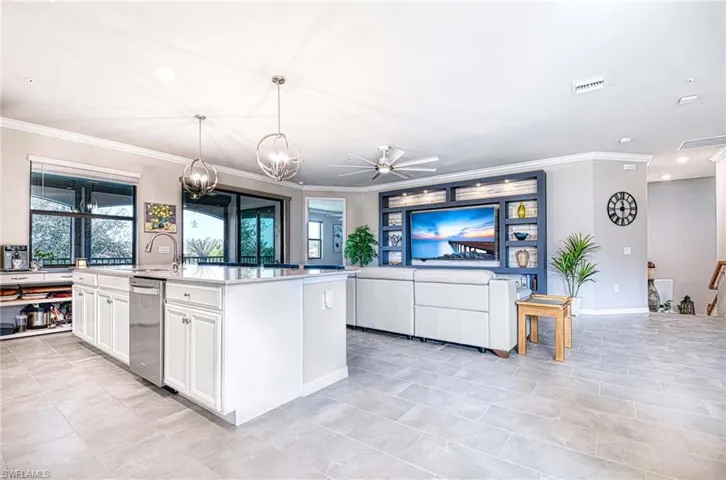 Kitchen featuring open floor plan, crown molding, white cabinetry, hanging light fixtures, and recessed lighting