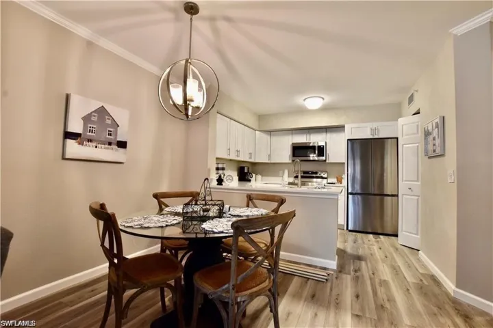 Dining room featuring light wood-style floors and crown molding