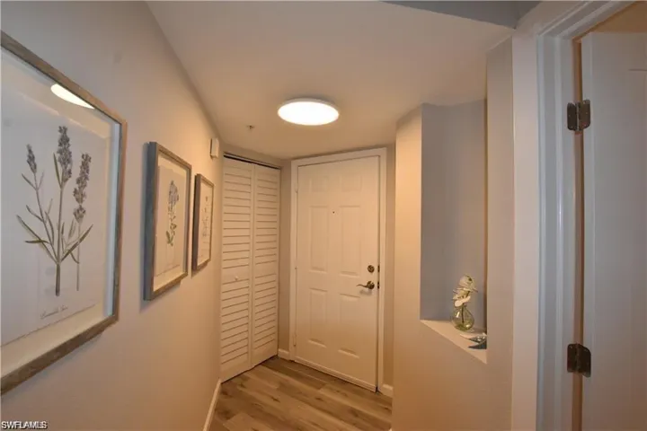 Doorway featuring wood finished floors and baseboards