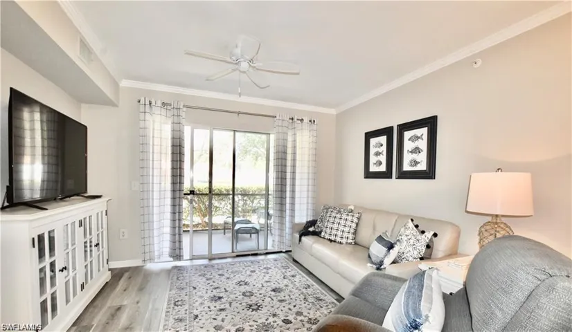 Living area with ornamental molding, wood finished floors, and a ceiling fan