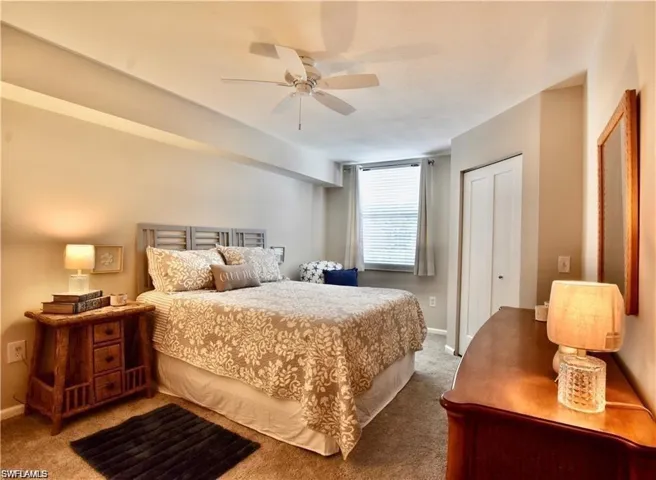 Carpeted bedroom featuring a closet and ceiling fan