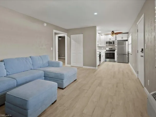 Living room featuring light wood-style flooring and a ceiling fan