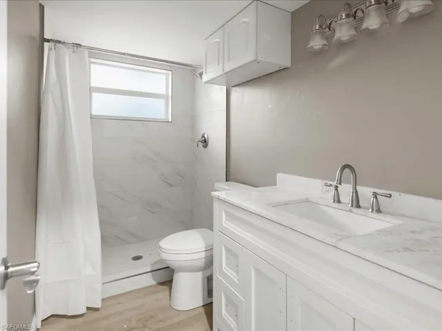 Bathroom with vanity, a stall shower, and light wood-type flooring