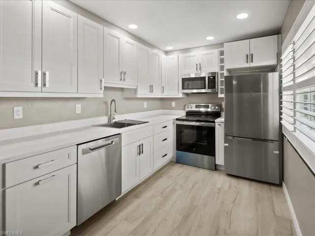 Kitchen with appliances with stainless steel finishes, white cabinetry, recessed lighting, and light wood finished floors