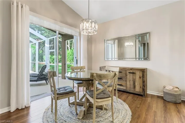 Dining room featuring a chandelier, wood finished floors, and vaulted ceiling