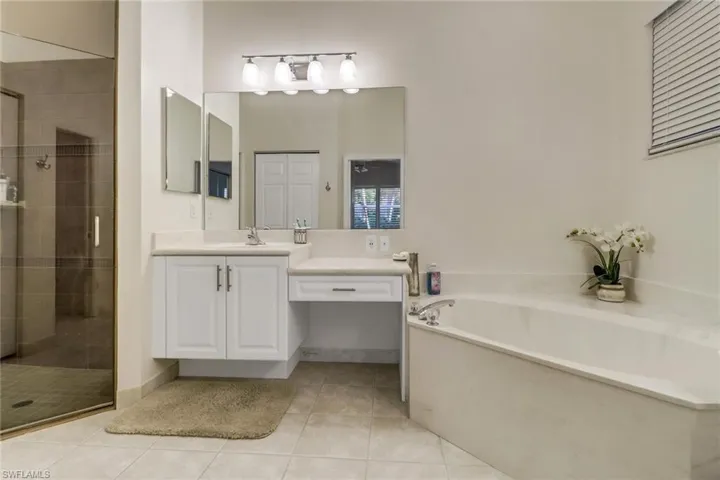 Bathroom with a bath, vanity, a shower stall, and tile patterned flooring
