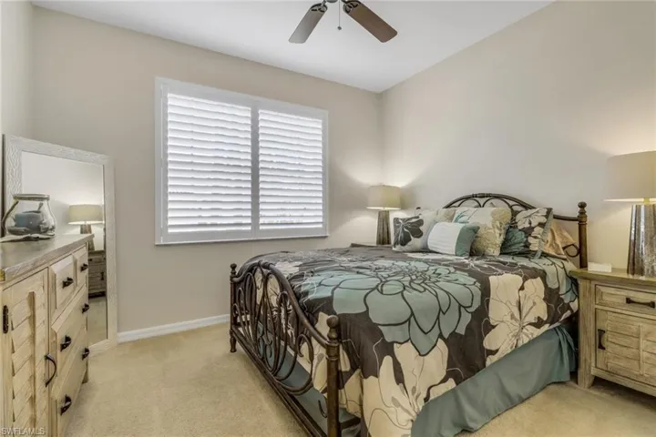 Bedroom featuring light colored carpet and ceiling fan