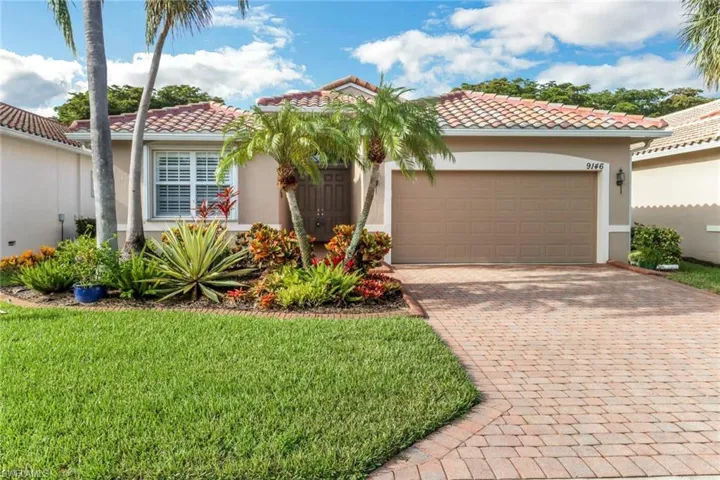 Mediterranean / spanish-style home with a tile roof, decorative driveway, stucco siding, an attached garage, and a front yard