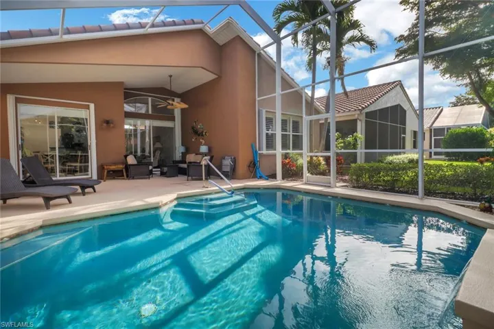Swimming pool featuring glass enclosure, a patio, a ceiling fan, and an outdoor living space