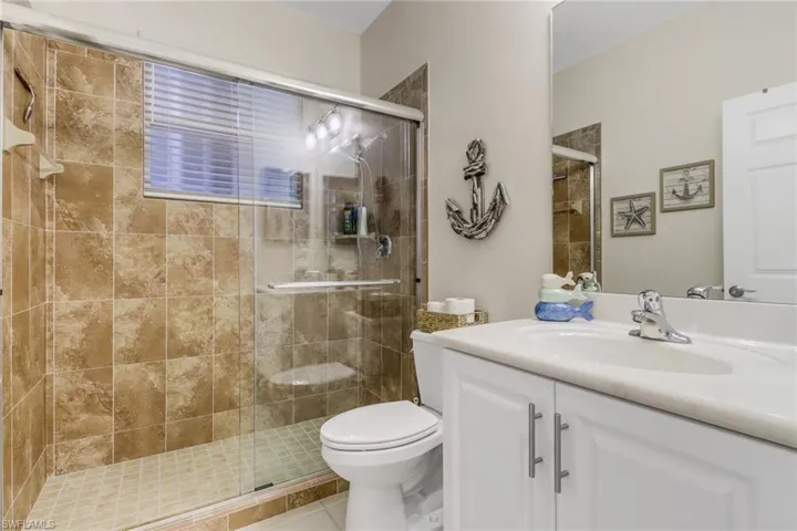 Bathroom with vanity, a stall shower, and tile patterned floors