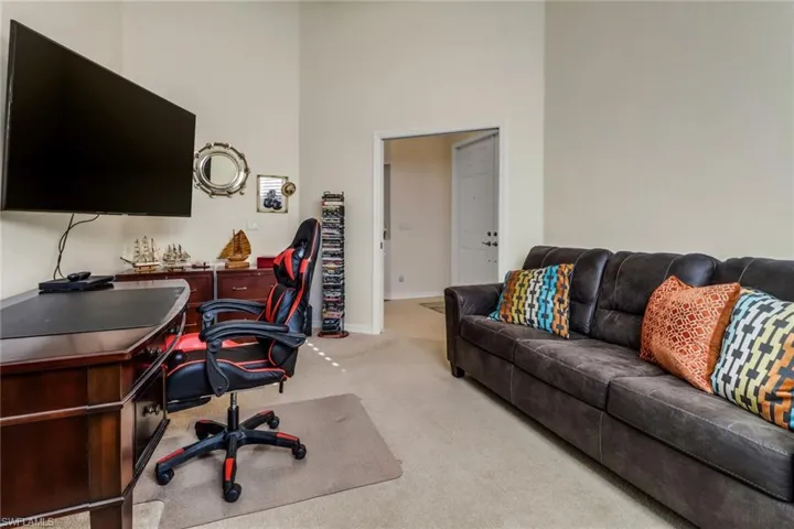 Office area with light colored carpet and a towering ceiling