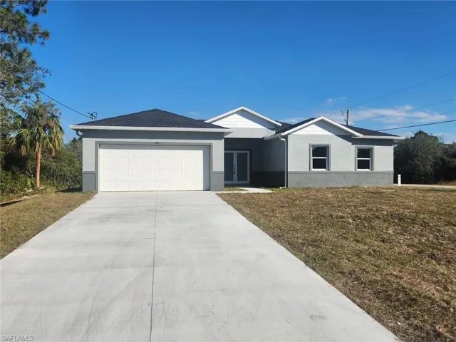 Ranch-style house with a garage and a front lawn