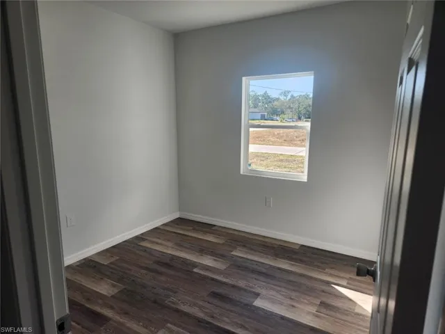 Empty room featuring dark hardwood / wood-style flooring