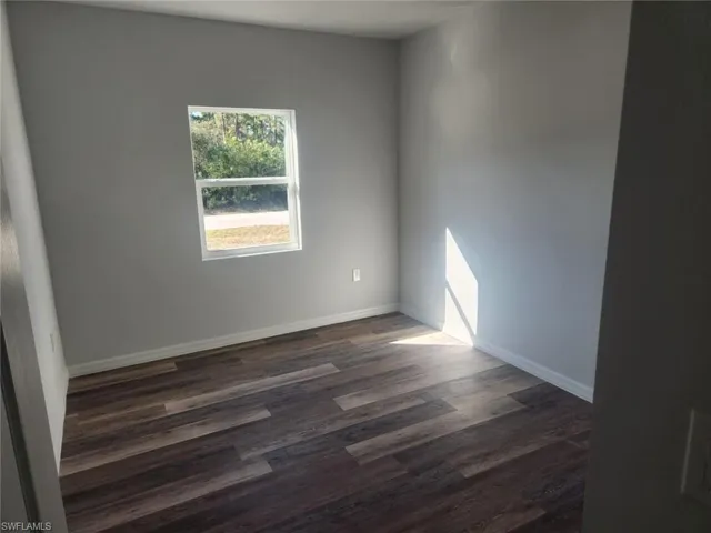 Unfurnished room with dark hardwood / wood-style flooring