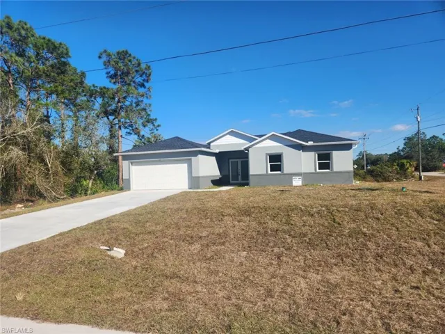 Single story home featuring a front yard and a garage