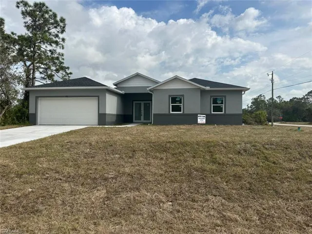 Ranch-style house featuring a garage and a front yard