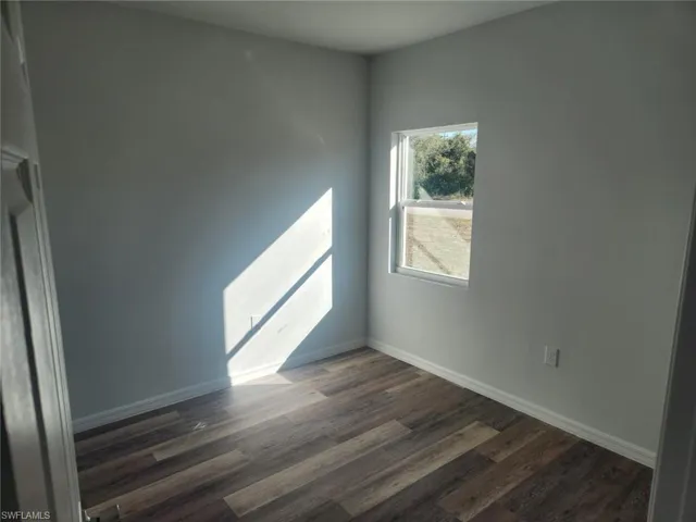 Unfurnished room featuring dark hardwood / wood-style floors