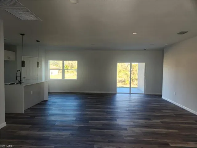 Unfurnished living room with sink and dark hardwood / wood-style floors