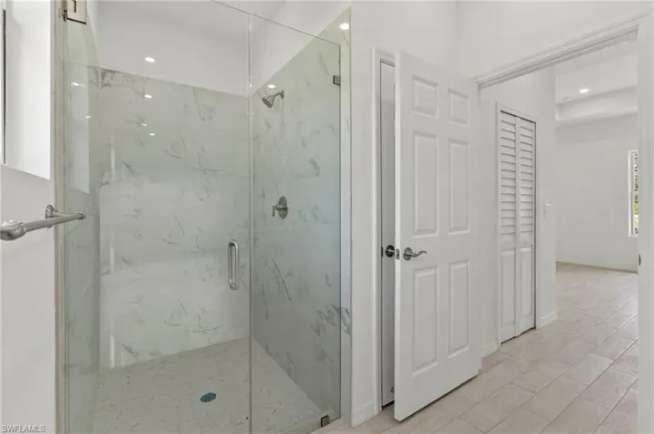 Bathroom featuring tile floors and a shower with shower door