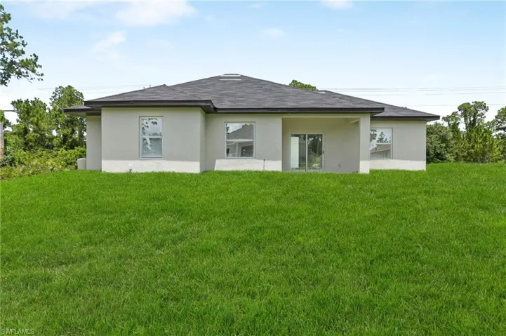 Back of house featuring a yard