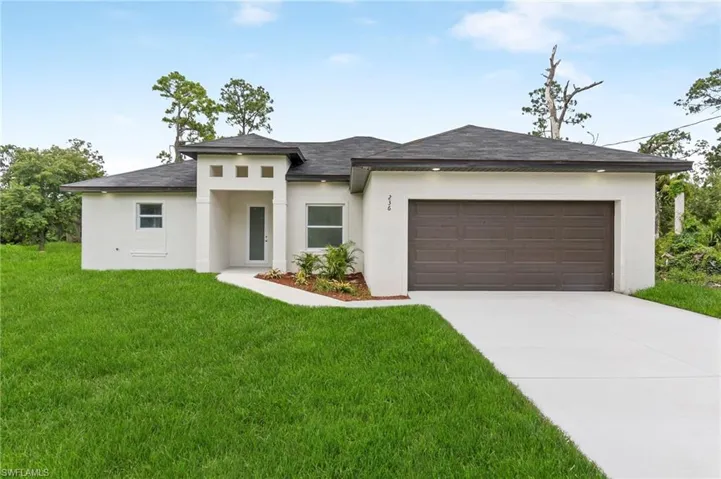 Prairie-style home with a garage and a front yard