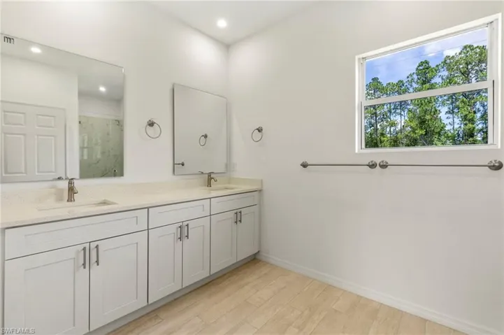 Bathroom featuring dual vanity and hardwood / wood-style floors