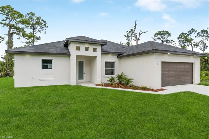 Prairie-style house featuring a garage and a front lawn