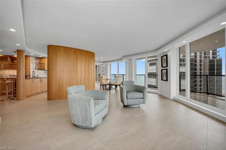 Tiled living room with floor to ceiling windows and sink